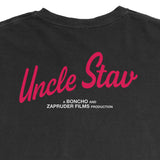 Close-up of the back of a black t-shirt featuring a red script graphic that reads 'Uncle Stav' with smaller white text underneath reading 'A BONCHO AND ZAPRUDER FILMS PRODUCTION'.